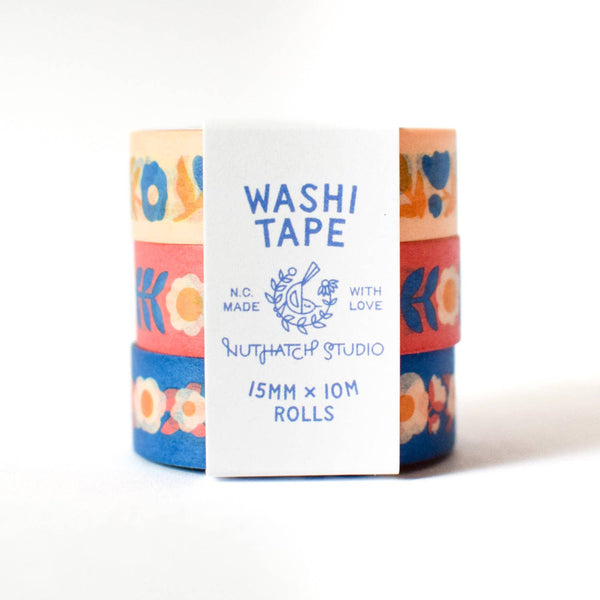 Three rolls of washi tape with colorful floral designs on a white background