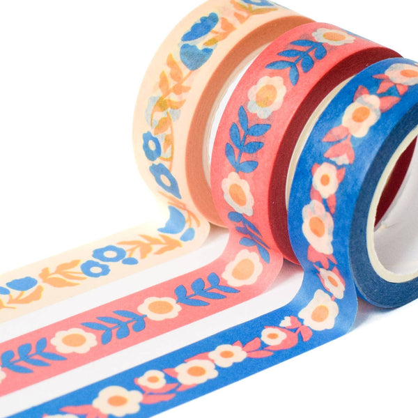 Set of three colorful floral washi tape rolls on a white background