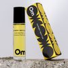 Perfume roll-on bottle and packaging with 'Om' branding on a light gray background