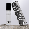 Om Vanilla Moon scented roller bottle with packaging on a light gray background