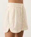 Cream shorts with a drawstring and curved hem on a light gray background