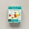 A boxed mini craft kit labeled 'Mini Craft Kit Bag Charm Pals' by Petit Collage, shown against a plain light wall. The package features colorful illustrations of bag charms including a red strawberry, yellow bee, brown bear, mushroom, and flower, with a black '6+' age mark and a choking hazard warning.