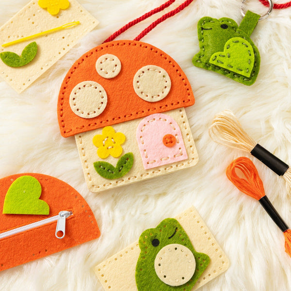 A white fur rug backdrop laid out with a felt craft kit for a toadstool purse and bag charm, along with embroidery floss and a kid-safe needle. 