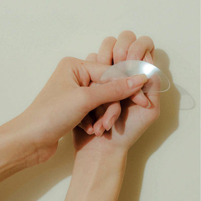 Hand holding a polishing glass against nail.