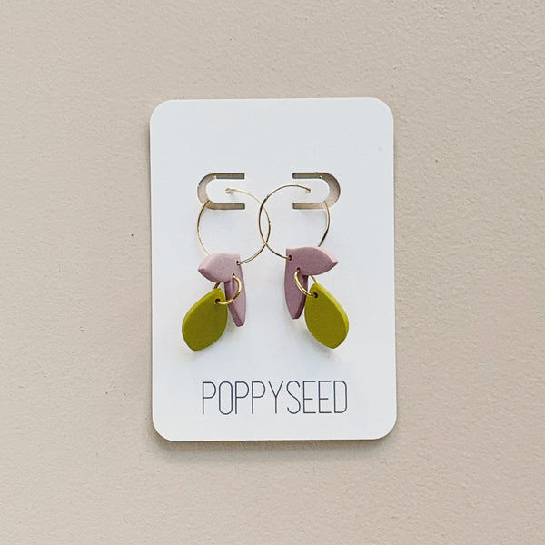 A pair of gold hoop earrings with lilac and chartreuse floral clay drop accents. 