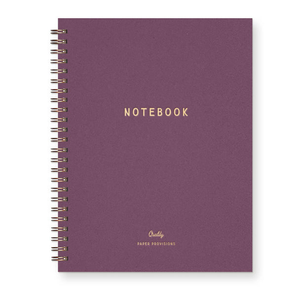 A plum purple spiralbound lined with "NOTEBOOK" gold foil printed across the center against a white background.