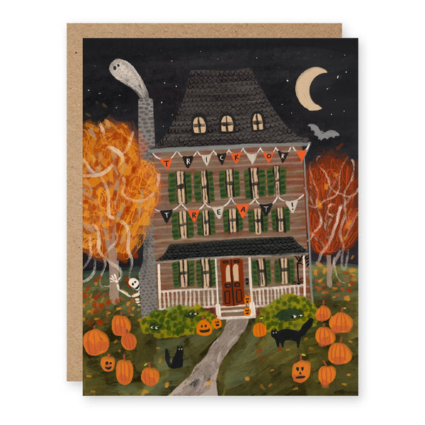 A Halloween themed greeting card depicting a spooky house decorated with jack'o'lanterns, garlands, and black cats, along with a skeleton, bat, ghost, and crescent moon. The card is paired with a kraft paper envelope.