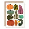 A greeting card featuring a watercolor-style illustration of multiple pumpkins and gourds in autumn colors, shown with a kraft paper envelope behind it on a white background.