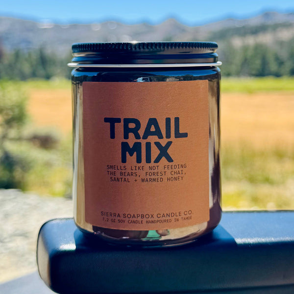 Trail Mix candle in a jar with a scenic background