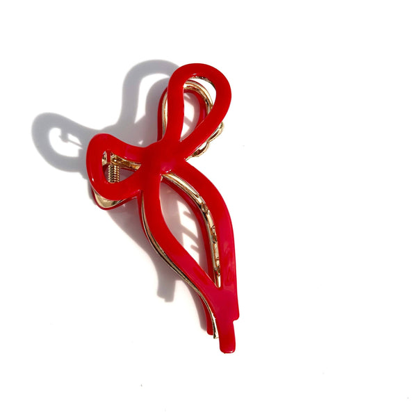 Red bow-shaped hair claw with gold interior on a white background