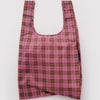 A nylon shopping bag in a deep pink and green plaid pattern against a white backdrop.