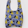 A nylon shopping bag in light purple with a design of golden yellow pears and dark leaves and stars against a white backdrop.