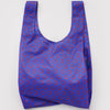 A nylon shopping bag in vibrant cobalt blue with mini red smiley faces on a white backdrop.
