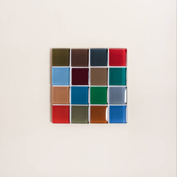 A glass mosaic tile coaster in a rich array of colors against a neutral background.
