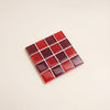 Red and dark red glass mosaic tile coaster against a neutral background.