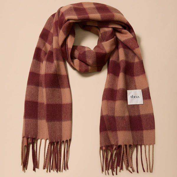A large lambswool fringed scarf in a rich fig and warm tan gingham pattern against a neutral background.