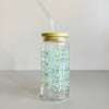 Glass travel cup featuring a blue quilt print with white and green tulips. The cup includes a bamboo lid and glass straw. 