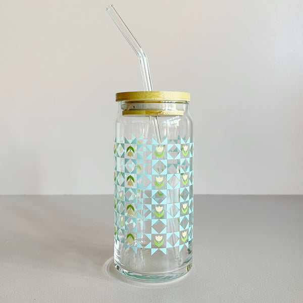 Glass travel cup featuring a blue quilt print with white and green tulips. The cup includes a bamboo lid and glass straw. 