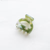 A marbled green small arch claw clip against a white background. 