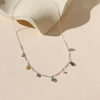 A sterling silver chain necklace featuring different colored natural stone charms against a neutral background.