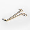A gold finish metal candle wick trimmer against a white background.
