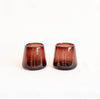 Two amethyst handblown glass tumblers on a white background