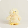 A soft plush toy chick with fluffy pale yellow fur, a bright yellow beak, and bright yellow feet, centered against a warm off-white background.