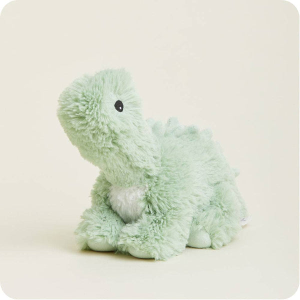 A light mint green plush dinosaur toy with a small white chest patch and a black bead eye, sitting on a warm off-white background.