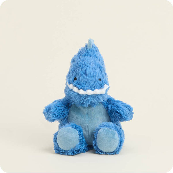 Blue plush T-Rex toy with a smiling face on a light beige background