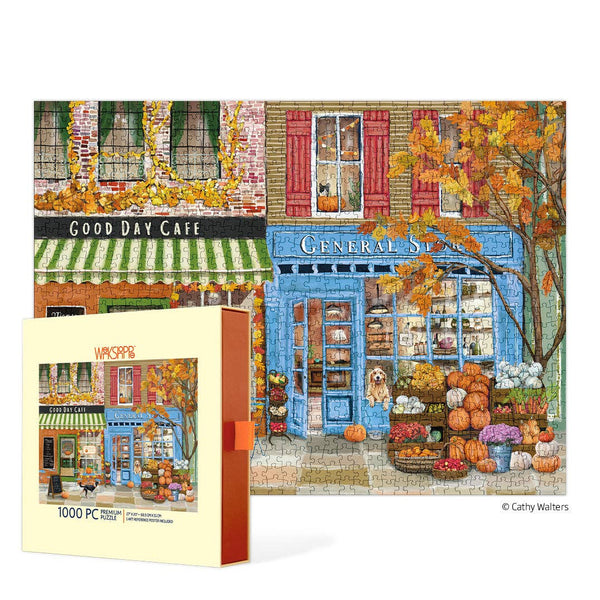 Jigsaw puzzle box with a colorful illustration of a small town autumnal street scene featuring a cafe and general store.