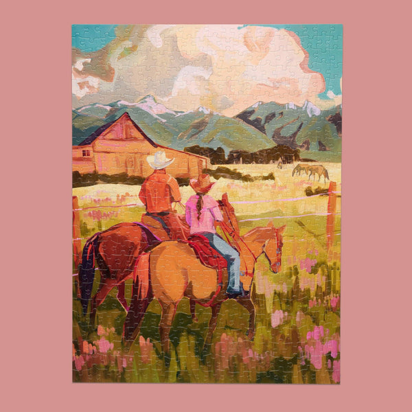 A painterly jigsaw puzzle depicting a cowboy and cowgirl riding horses across a grassy field with a barn, mountains, and a cloudy sky. The puzzle is centered on a solid pink background.