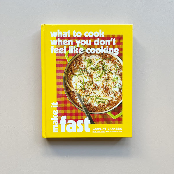 A bright yellow cookbook titled 'What to Cook When ou Don't Feel Like Cooking: Make It Fast' by Caroline Chambers against a neutral background. 