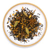 A loose leaf blend of black tea house chai on a white ceramic plate against a white surface.