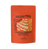 A bright orange stand-up pouch of Wild & Tea Toasted Coconut Horchata Herbal Red Tea loose leaf, featuring a stylized graphic of a coconut with red, orange, and cream stripes, on a plain white background.