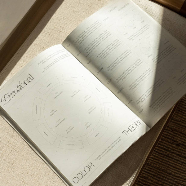 Open guidebook on a textured surface with 'Emotional Color Theory' visible.