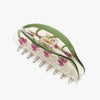 Hair claw with green handle and pink floral design on a white background