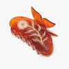 Orange hair comb with chamomile floral design on a white background