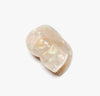 Shell-shaped iridescent off-white hair claw with a gold spiral design on a white background